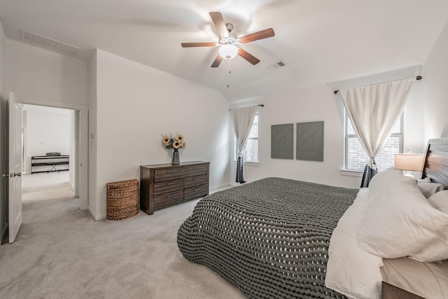 carpeted bedroom featuring lofted ceiling, ceiling fan, and visible vents