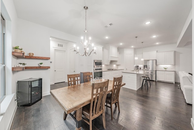 dining space with dark wood-style flooring, an inviting chandelier, visible vents, and recessed lighting