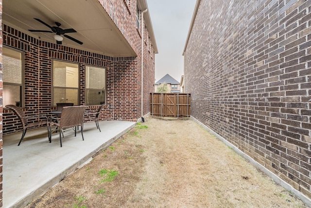 view of yard with a gate, ceiling fan, a patio, and fence