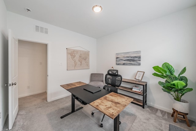 office area with baseboards, visible vents, and light colored carpet