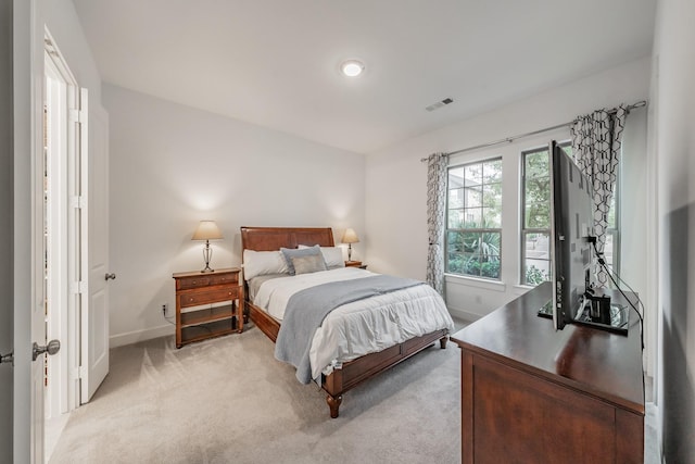 bedroom with baseboards, visible vents, and light colored carpet