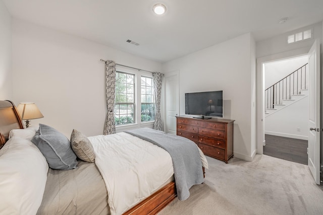 bedroom featuring light carpet, baseboards, and visible vents