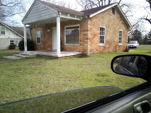 rear view of house with a lawn and roof with shingles