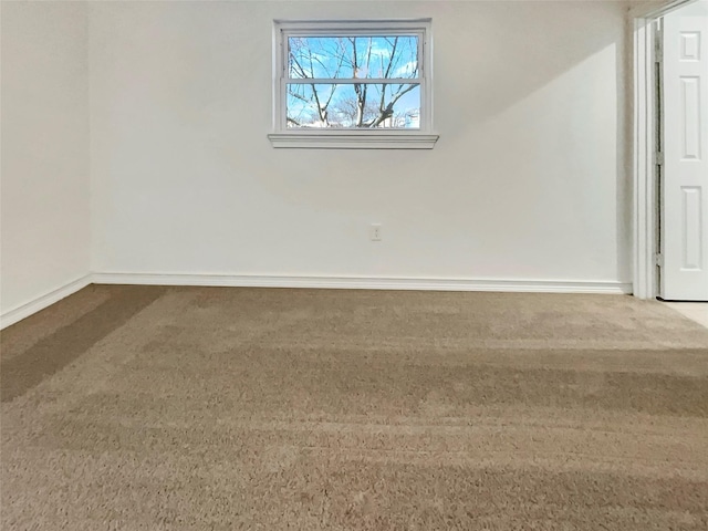 carpeted spare room featuring baseboards