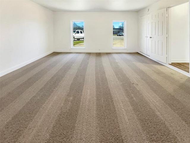 empty room with carpet floors and baseboards