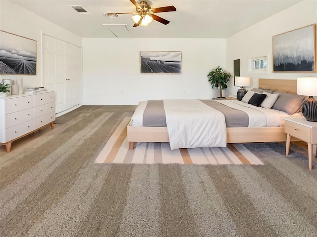 bedroom with carpet floors, attic access, visible vents, and ceiling fan