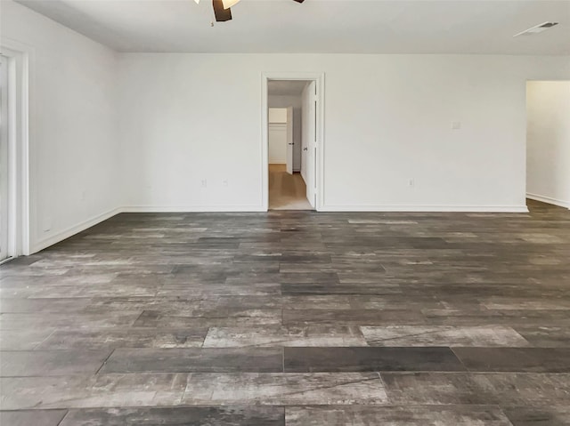 spare room featuring baseboards, ceiling fan, visible vents, and wood finished floors