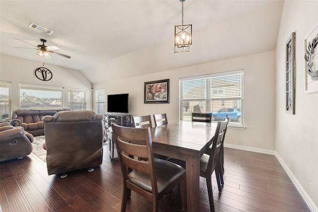 dining area featuring visible vents, dark wood-type flooring, vaulted ceiling, baseboards, and ceiling fan with notable chandelier