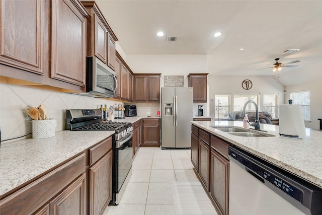 kitchen with visible vents, a sink, stainless steel appliances, backsplash, and light tile patterned flooring