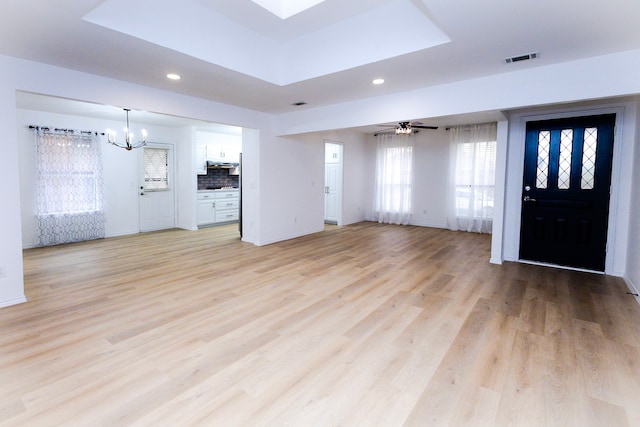 unfurnished living room featuring light wood-style floors, recessed lighting, visible vents, and ceiling fan with notable chandelier