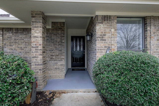 doorway to property featuring brick siding