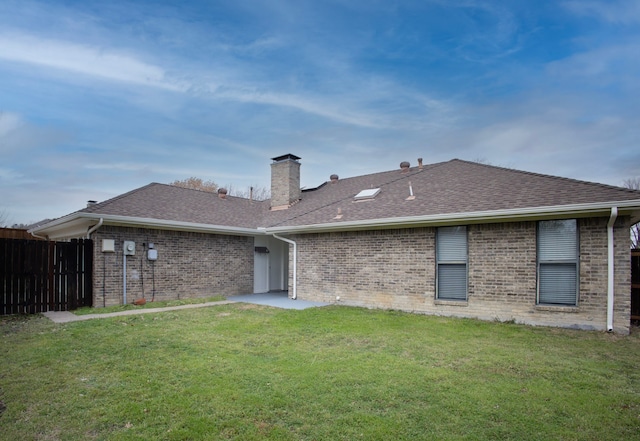 rear view of house featuring a yard, brick siding, and roof with shingles