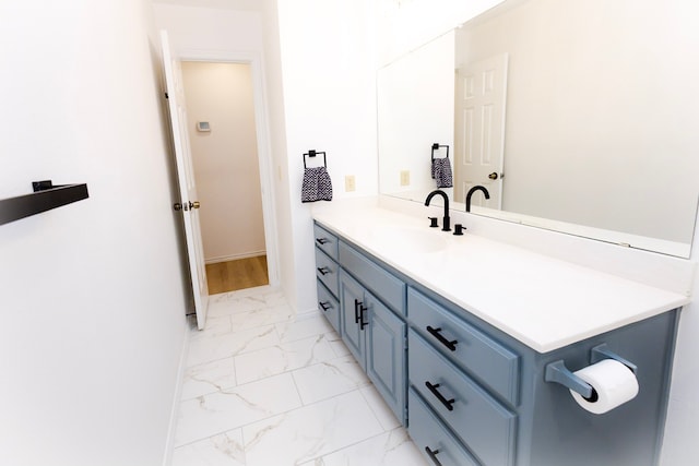 bathroom with marble finish floor, baseboards, and vanity