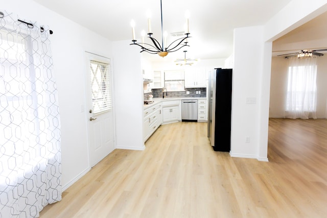 kitchen with stainless steel appliances, light wood finished floors, backsplash, and light countertops