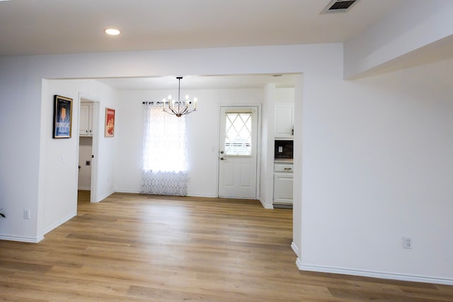 unfurnished dining area featuring recessed lighting, visible vents, baseboards, light wood-style floors, and an inviting chandelier