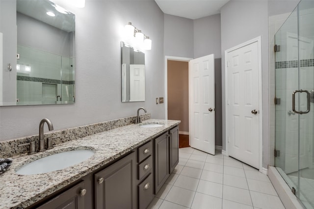 bathroom featuring a stall shower, tile patterned floors, a sink, and double vanity