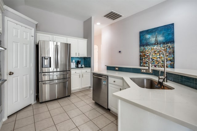 kitchen with light tile patterned floors, stainless steel appliances, visible vents, backsplash, and a sink