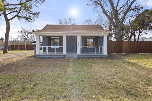 bungalow featuring a porch, a front lawn, fence, and brick siding