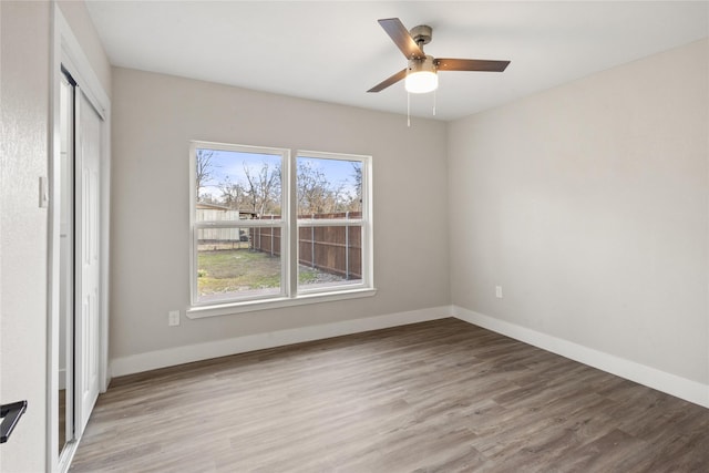 unfurnished bedroom featuring a ceiling fan, a closet, light wood-style flooring, and baseboards