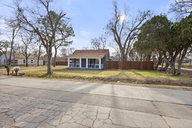 view of front of property with a front lawn and fence