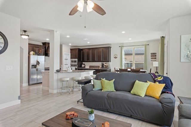 living area featuring light wood-style floors, recessed lighting, baseboards, and a ceiling fan