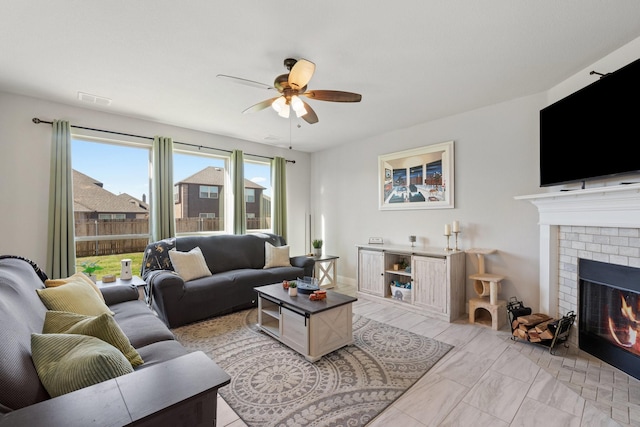 living area featuring visible vents, a fireplace, and a ceiling fan