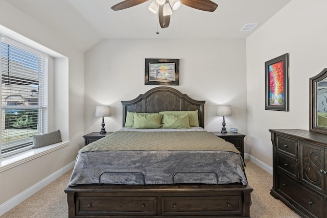 bedroom with lofted ceiling, light colored carpet, visible vents, and baseboards