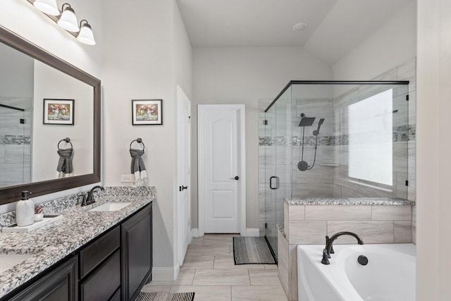 full bathroom with double vanity, lofted ceiling, a garden tub, a shower stall, and a sink