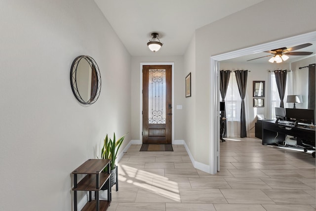 foyer featuring ceiling fan and baseboards