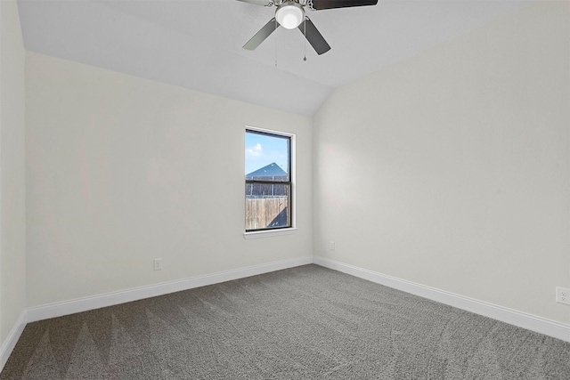 empty room featuring ceiling fan, baseboards, dark carpet, and vaulted ceiling