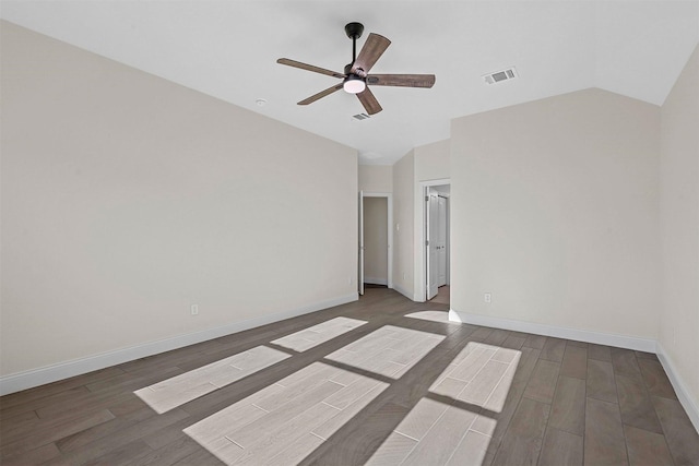 spare room with lofted ceiling, visible vents, ceiling fan, wood finished floors, and baseboards