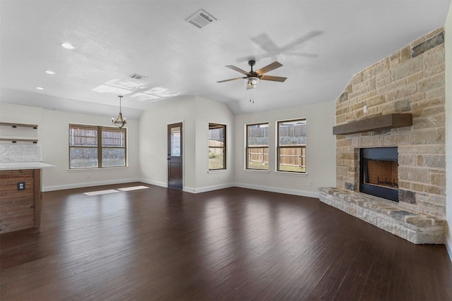 unfurnished living room with dark wood-style floors, visible vents, plenty of natural light, and a stone fireplace