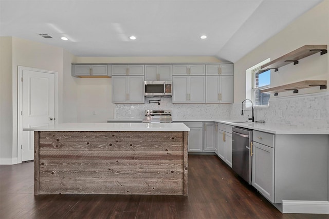 kitchen featuring stainless steel appliances, gray cabinets, visible vents, and open shelves