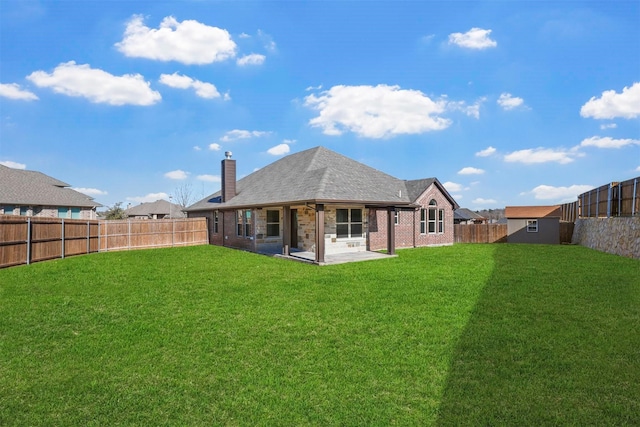 rear view of property with a patio, brick siding, a lawn, and a fenced backyard