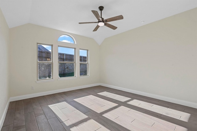 spare room with lofted ceiling, wood finish floors, and baseboards