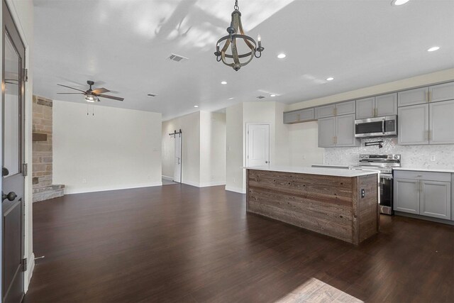 kitchen with dark wood-style flooring, stainless steel appliances, visible vents, backsplash, and gray cabinetry