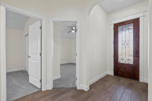 foyer with baseboards, arched walkways, and wood finished floors