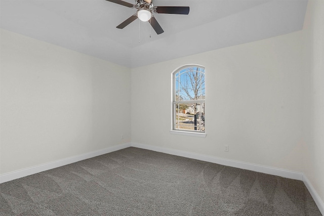 empty room featuring ceiling fan, baseboards, and dark colored carpet