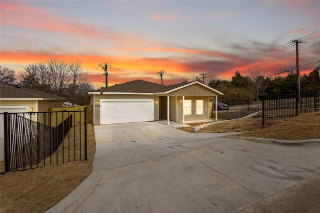 view of front facade featuring concrete driveway, a shingled roof, an attached garage, and fence