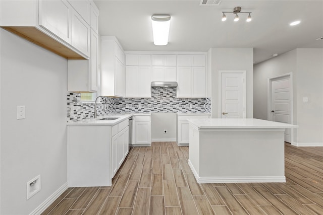 kitchen with wood tiled floor, visible vents, backsplash, and a sink