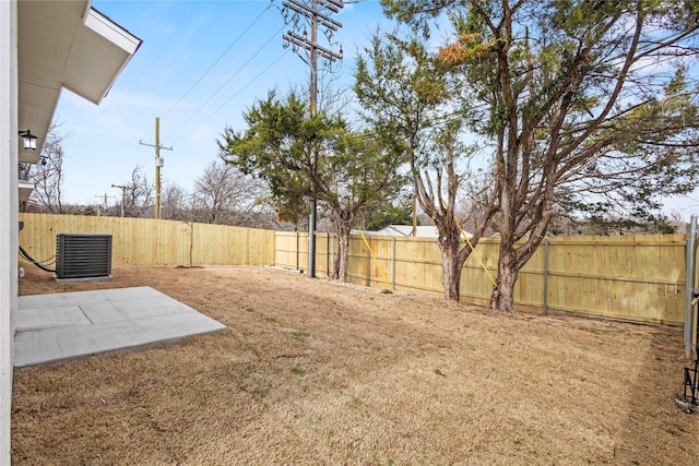view of yard featuring a fenced backyard, central AC, and a patio