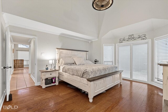 bedroom with dark wood-type flooring, access to exterior, and multiple windows