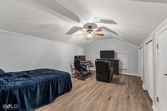 bedroom featuring light wood-type flooring, baseboards, a ceiling fan, and lofted ceiling