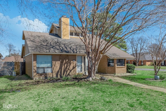 view of front of home featuring roof with shingles, a chimney, a front lawn, and brick siding