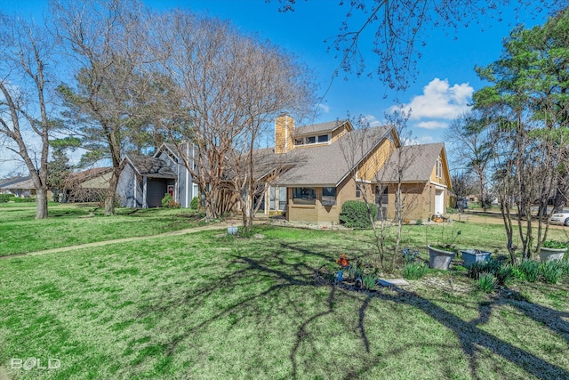 view of front facade featuring a garage, brick siding, a chimney, and a front yard