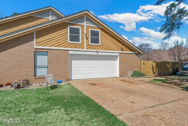 view of side of property featuring a garage, brick siding, fence, driveway, and a lawn