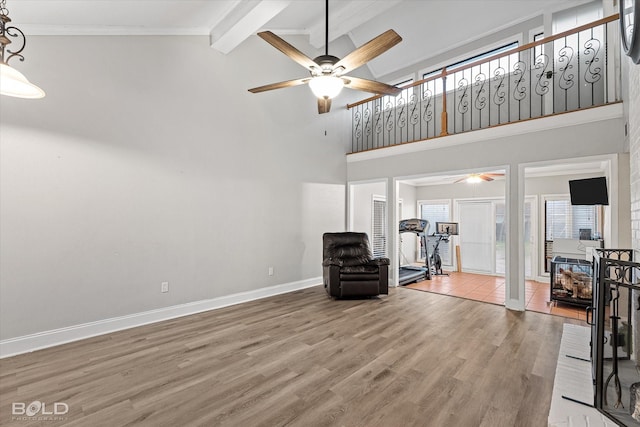 sitting room with ceiling fan, high vaulted ceiling, baseboards, light wood finished floors, and beamed ceiling