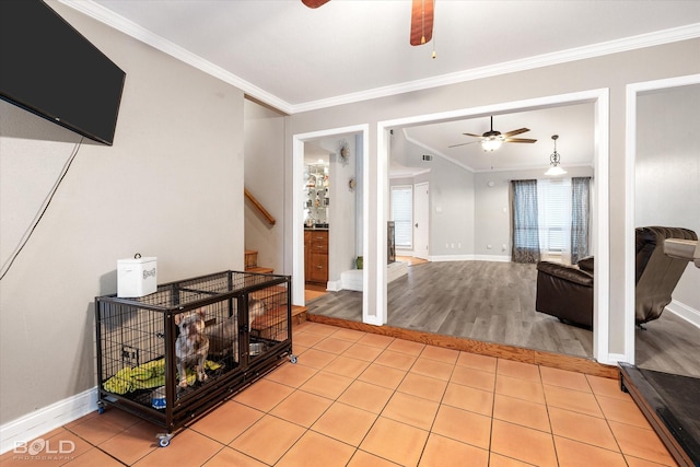 interior space with light tile patterned floors, ceiling fan, stairs, and ornamental molding