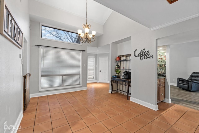 interior space with a towering ceiling, light tile patterned floors, and baseboards