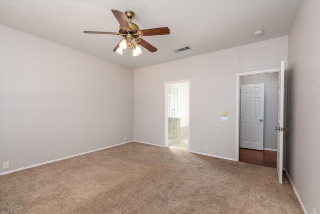 spare room with carpet floors, baseboards, visible vents, and a ceiling fan